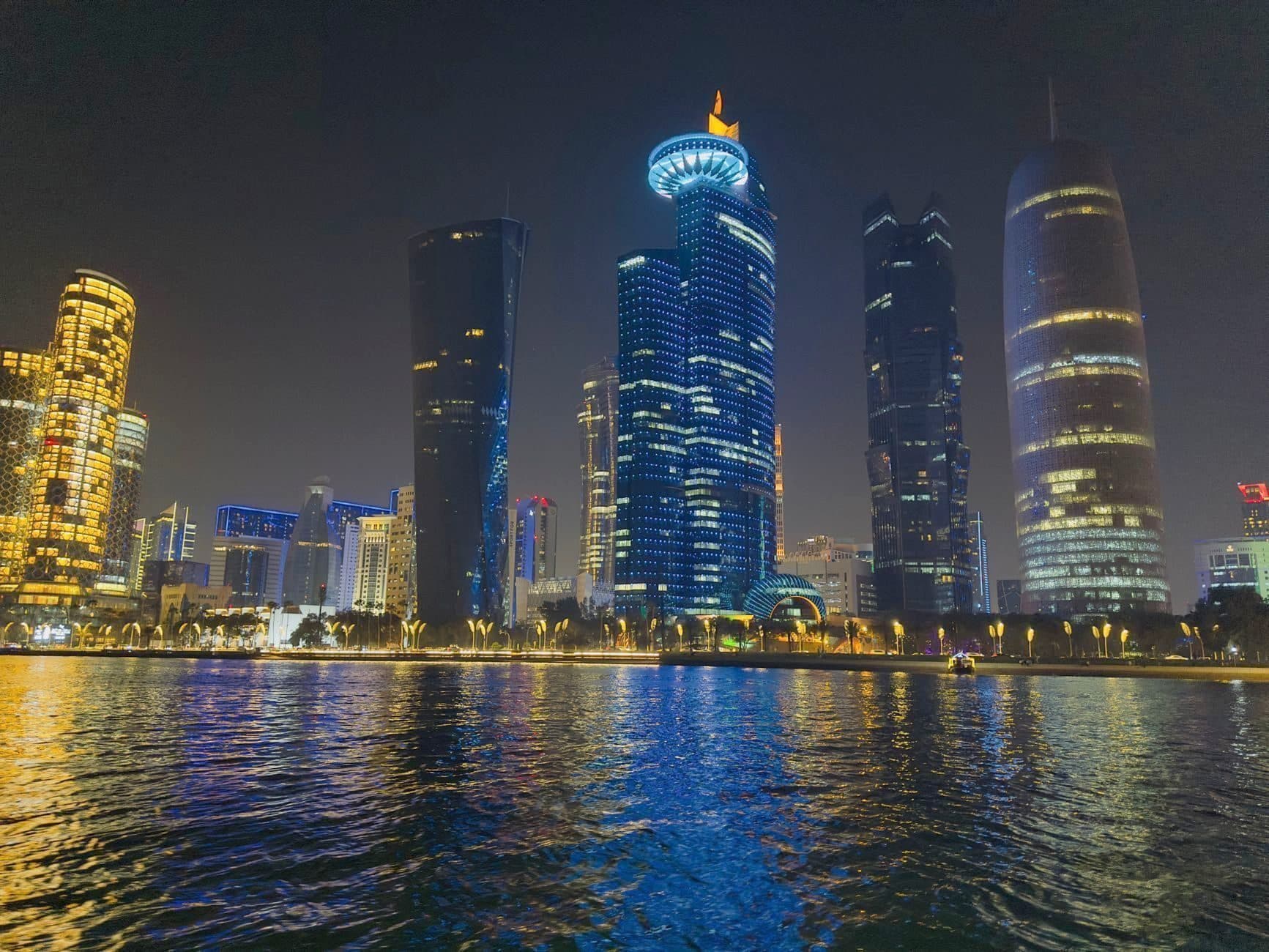 The Doha skyline at night, lit and reflected on the water