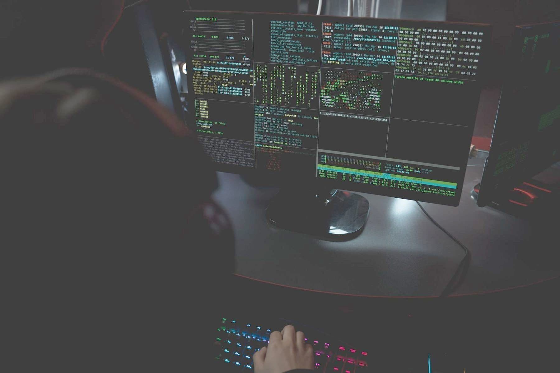 Code on monitors in a darkened security operations room