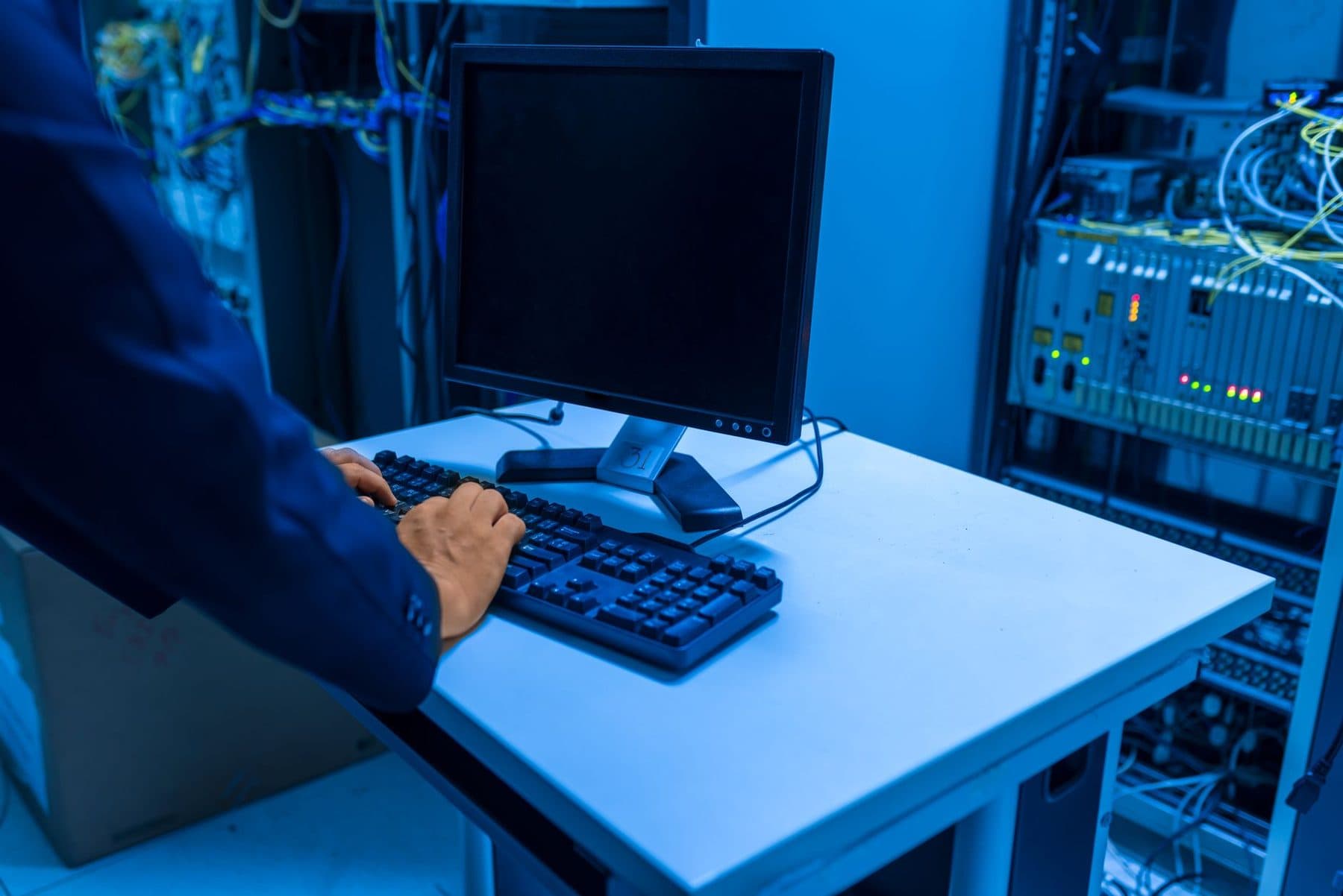 An engineer at a workstation in a server room