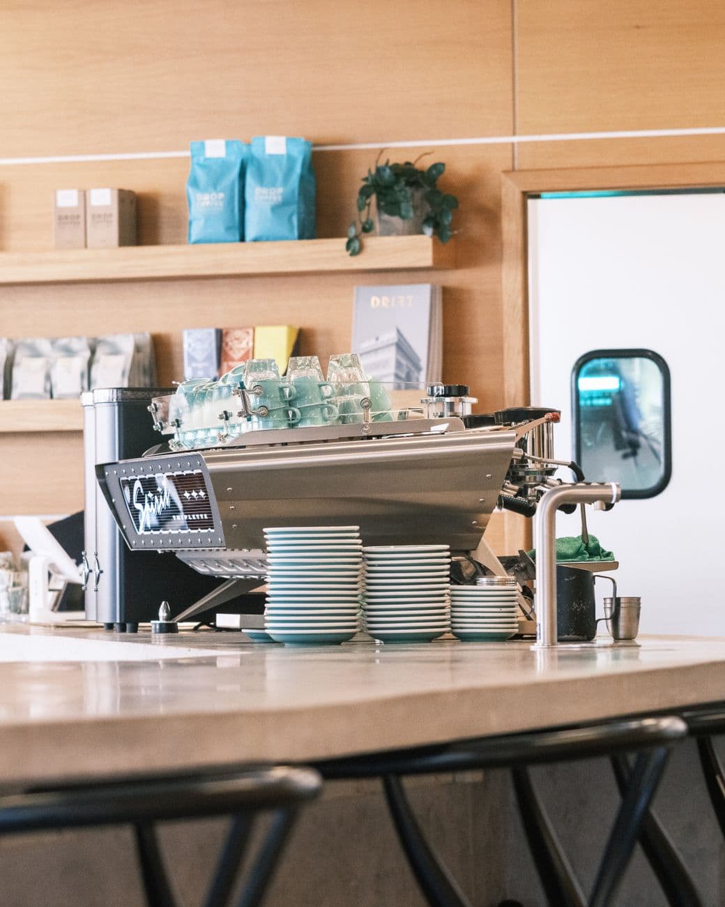 A coffee shop counter with an espresso machine and menu board