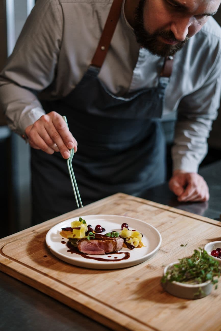A chef plating a dish in a professional kitchen