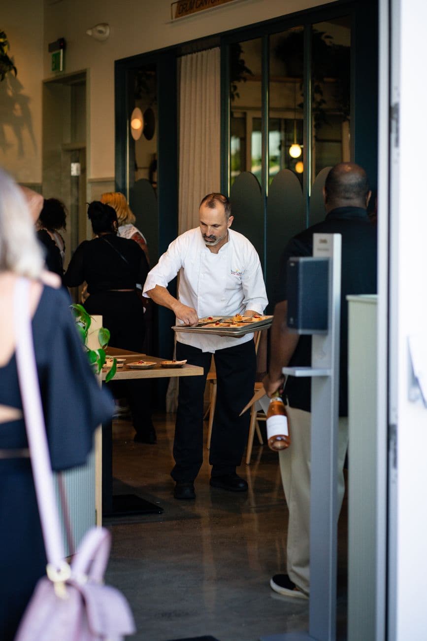 A server carrying plates through a busy dining room