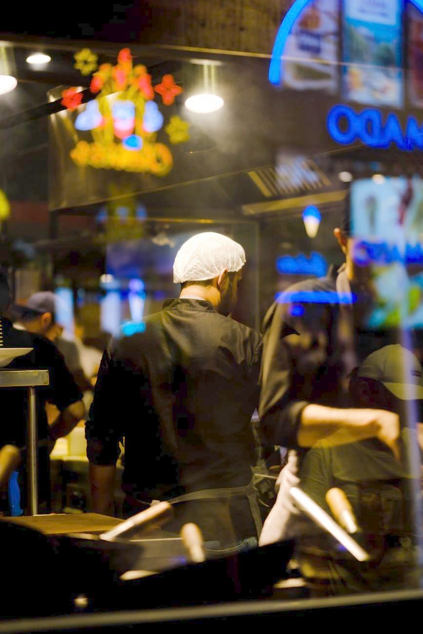 A chef working the pass in a restaurant kitchen at night