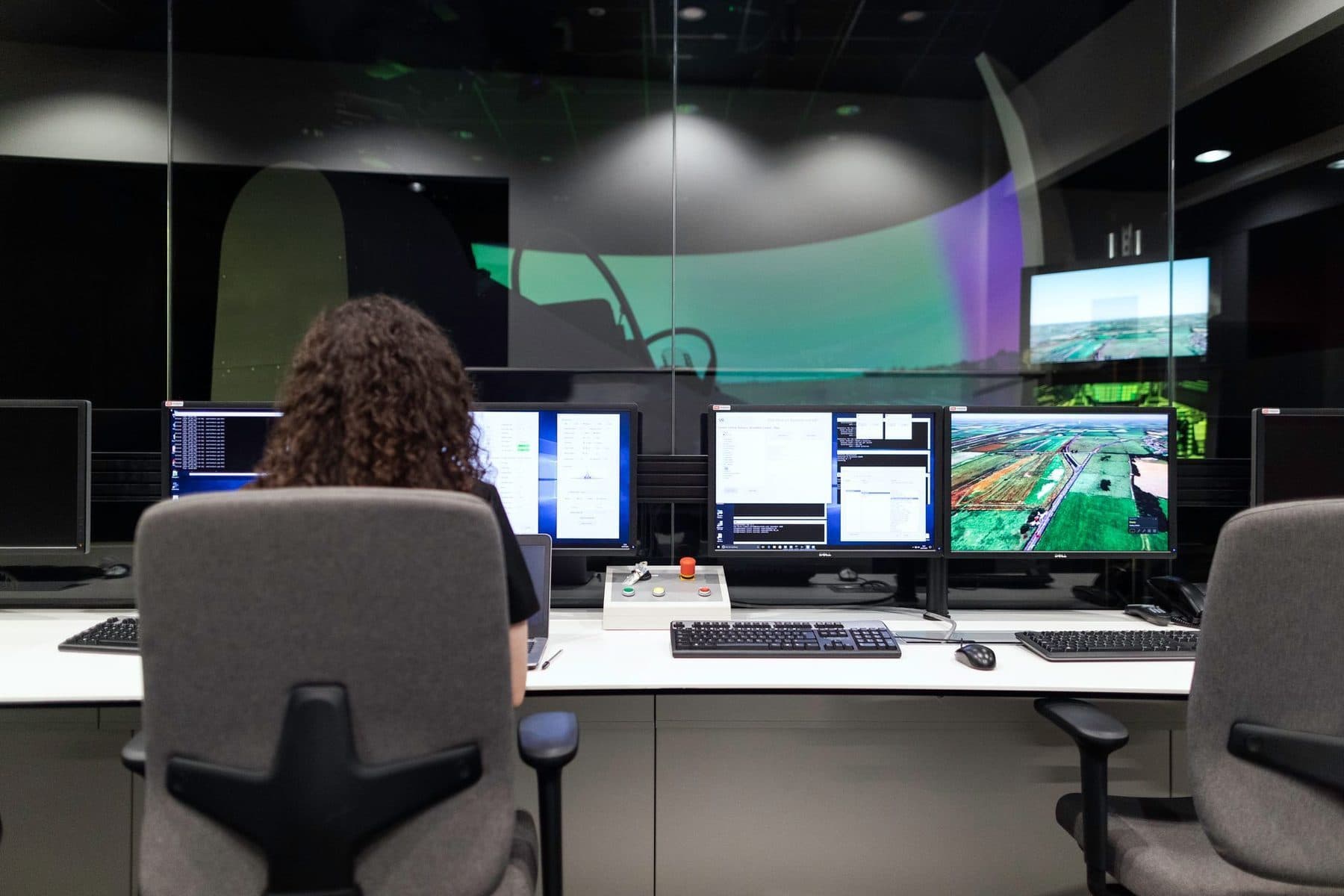 An engineer working across several screens during a build